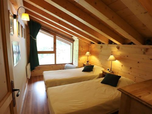 deux lits dans une chambre aux murs en bois dans l'établissement Superbe duplex au pied des pistes avec garage et terrasse - FR-1-342-231, à Beaufort