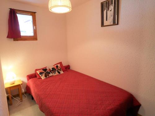 um quarto com uma cama vermelha com duas almofadas em Appartement Arêches-Beaufort, 2 pièces, 6 personnes - FR-1-342-256 em Beaufort