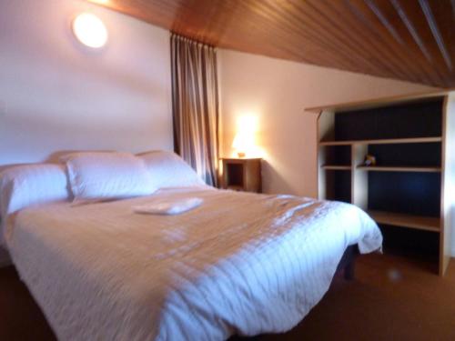 1 dormitorio con 1 cama con colcha blanca en Appartement Arette, 2 pièces, 6 personnes - FR-1-602-83, en Arette