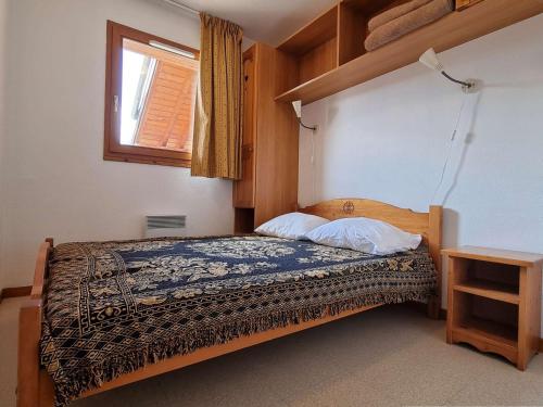 - une chambre avec un lit en bois et une fenêtre dans l'établissement Appartement cosy 2 pièces avec balcon, proche télésiège - 6 couchages - Dévoluy - FR-1-525-197, à Saint-Étienne-en-Dévoluy