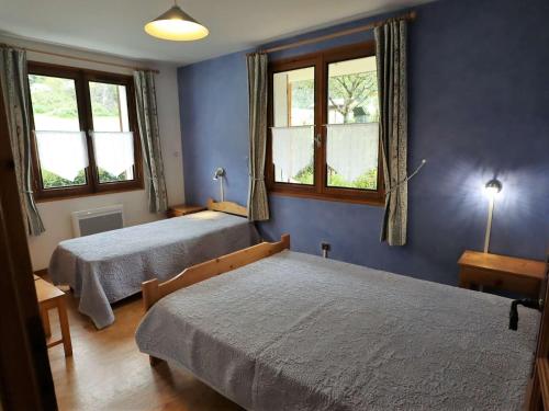 Duas camas num quarto com paredes e janelas azuis em Appartement Arêches-Beaufort, 3 pièces, 4 personnes - FR-1-342-236 em Beaufort