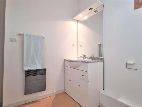 une salle de bain blanche avec un lavabo et un miroir dans l'établissement Appartement 8 pers avec balcon, proche commerces et pistes, casier à ski - FR-1-525-199, à Saint-Étienne-en-Dévoluy