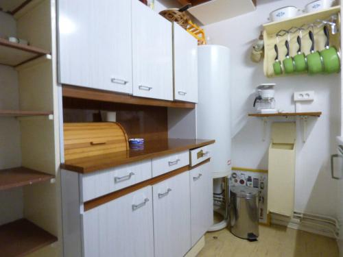 cocina con armarios blancos y encimera en Appartement Arette, 2 pièces, 6 personnes - FR-1-602-83, en Arette