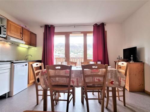 une cuisine avec une table et des chaises dans une cuisine dans l'établissement Appartement 8 pers avec balcon, proche commerces et pistes, casier à ski - FR-1-525-199, à Saint-Étienne-en-Dévoluy