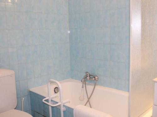 bagno piastrellato blu con vasca e servizi igienici di Appartement Cagnes-sur-Mer, 1 pièce, 4 personnes - FR-1-252A-56 a Cagnes-sur-Mer