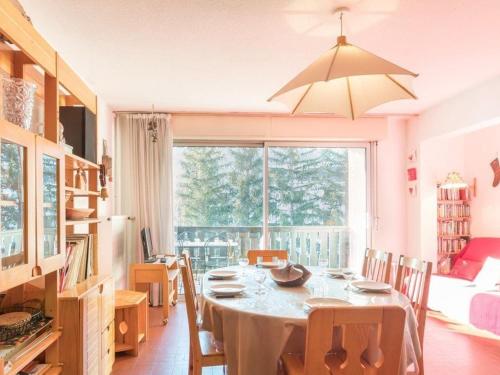 une salle à manger avec une table et une grande fenêtre dans l'établissement Appartement familial 3 pièces, 8 couchages, proche des pistes à Serre-Chevalier, balcon sud. - FR-1-330E-122, à Saint-Chaffrey
