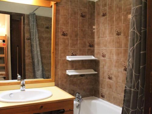 a bathroom with a sink and a tub and a mirror at Appartement Vars, 1 pièce, 4 personnes - FR-1-330B-178 in Vars