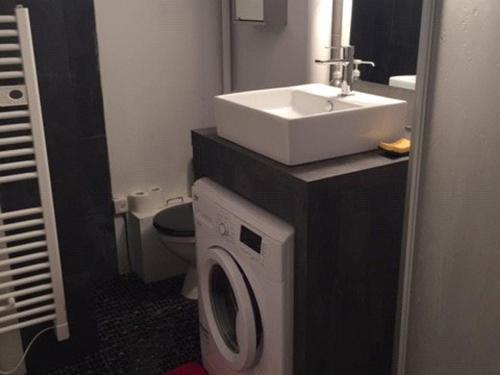 une salle de bain avec un lavabo et une machine à laver dans l'établissement Chalet cosy 6/8 pers. près des pistes avec équipements complets et parking gratuit - FR-1-602-92, à Arette