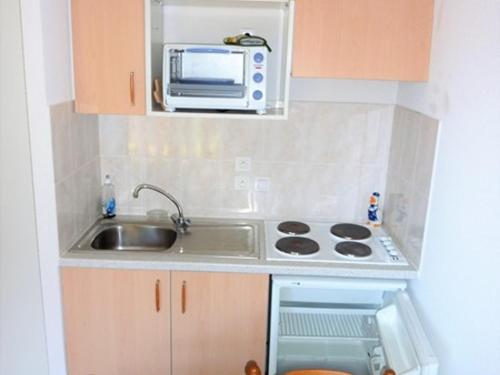 une petite cuisine avec un évier et un micro-ondes dans l'établissement Charmant T2 avec terrasse, parking et cave - 4 pers, proche randonnées et ski fond - FR-1-573-43, à Bonnevaux
