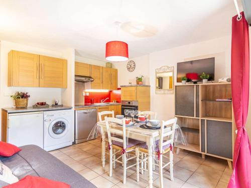 une cuisine et une salle à manger avec une table et des chaises dans l'établissement Appartement T2 plein sud avec jardin, terrasse et parking, proche centre et téléphérique - FR-1-296-353, à Saint-Lary-Soulan