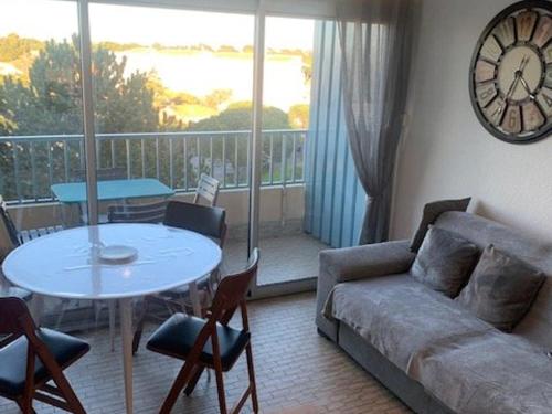 - un salon avec un canapé, une table et un réveil dans l'établissement Appartement à Argelès-sur-Mer, 200m de la plage, 4 pers., loggia, parking sécurisé - FR-1-388-197, à Argelès-sur-Mer