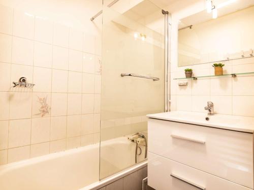 une salle de bain blanche avec un lavabo et une douche dans l'établissement Appartement T2 plein sud avec jardin, terrasse et parking, proche centre et téléphérique - FR-1-296-353, à Saint-Lary-Soulan