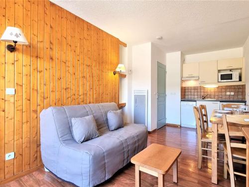 un salon avec un canapé bleu et une table dans l'établissement Appartement cosy avec terrasse, proche télésiège et piscine - 4 pers, Wifi inclus, Dévoluy - FR-1-525-217, à Saint-Étienne-en-Dévoluy