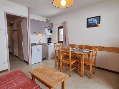 une cuisine et une salle à manger avec une table et des chaises dans l'établissement Appartement cosy 6 pers, balcon exposé, proche pistes et commerces, parking, navette, Wifi gratuit - FR-1-525-218, à Saint-Étienne-en-Dévoluy