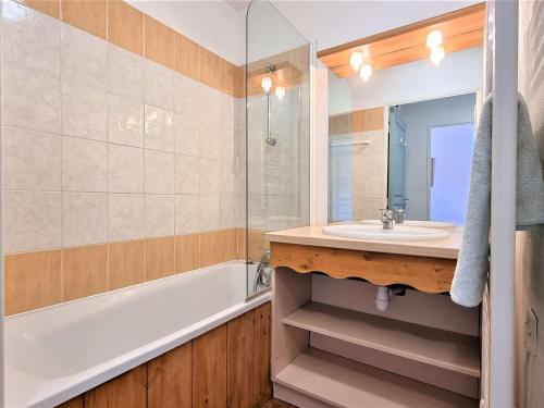 een badkamer met een wastafel, een bad en een spiegel bij Appartement Le Dévoluy, 2 pièces, 4 personnes - FR-1-525-217 in Le Dévoluy