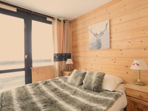a bedroom with a bed with a deer picture on the wall at Appartement Val Thorens, 3 pièces, 5 personnes - FR-1-637-3 in Val Thorens