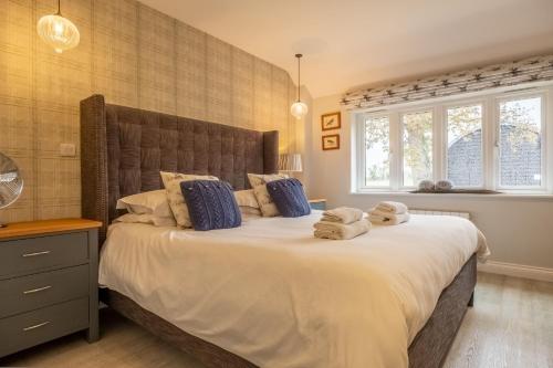 - une chambre avec un grand lit et des serviettes dans l'établissement The Cowshed at Green Valley Farm, à Laxfield