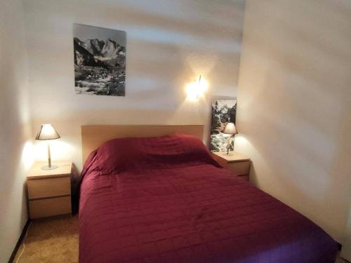 a bedroom with a red bed with two night stands at Appartement Cauterets, 3 pièces, 6 personnes - FR-1-234-263 in Cauterets