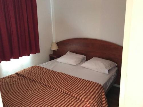 - une chambre dotée d'un lit avec une couverture rayée rouge et blanche dans l'établissement Charmant T2, 4 pers., parking, piscine couverte, salle de fitness, proche pistes et centre station - FR-1-404-329, à La Mongie