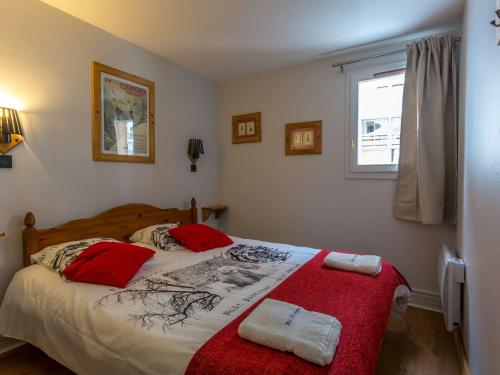 a bedroom with a bed with red pillows and a window at "Chalet Triplex 12 Pers à Val Thorens - 4 Flocons Or, Cheminée, WiFi, Proche Pistes et Commerces" - FR-1-637-10 in Val Thorens