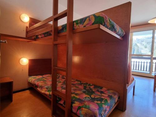 une chambre avec deux lits superposés et une fenêtre dans l'établissement Studio cosy 4 pers, terrasse, parking, wifi, proche commerces et télésiège - FR-1-525-232, à Saint-Étienne-en-Dévoluy
