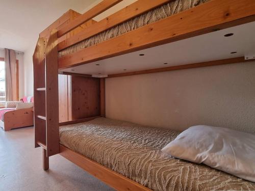 Cette chambre comprend un lit superposé en bois. dans l'établissement Appartement 2 pièces, parking, proche télésiège - Le Dévoluy - FR-1-525-226, à Saint-Étienne-en-Dévoluy