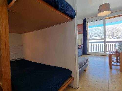 une chambre avec un lit superposé et une grande fenêtre dans l'établissement Studio cosy, front de neige, proche télésiège Le Jas, pour 4 personnes – SuperDévoluy. - FR-1-525-230, à Saint-Étienne-en-Dévoluy