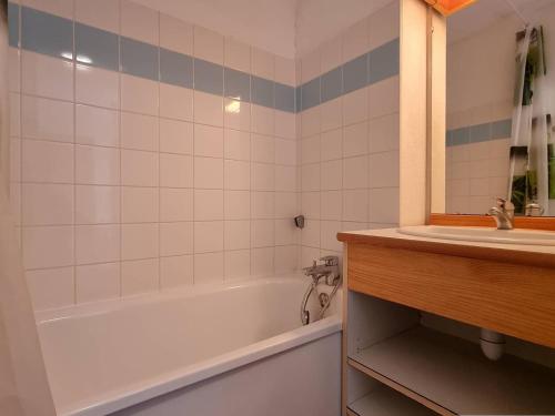 une salle de bain avec une baignoire blanche et un lavabo dans l'établissement Appartement 2 pièces, parking, proche télésiège - Le Dévoluy - FR-1-525-226, à Saint-Étienne-en-Dévoluy