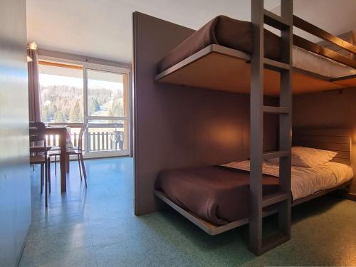 - une chambre avec des lits superposés et une salle à manger avec une table dans l'établissement Studio cosy proche pistes, 4 personnes, parking, wifi, animaux permis - FR-1-525-234, à Saint-Étienne-en-Dévoluy