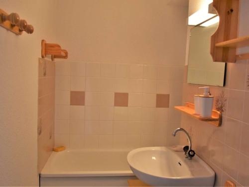a bathroom with a sink and a tub and a mirror at Appartement Risoul, 1 pièce, 4 personnes - FR-1-330-542 in Risoul