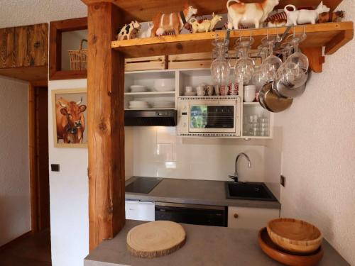 une cuisine avec une cuisinière, un évier et un micro-ondes dans l'établissement Appartement douillet à la montagne, 2-3 pers., balcon, près des commerces - FR-1-342-262, à Beaufort