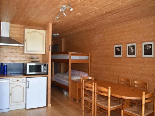 - une cuisine et une salle à manger avec une table et des lits superposés dans l'établissement Charmant T2 cabine 35m² avec terrasse, exposition sud-ouest, bien équipé, Bolquère, sans animaux - FR-1-592-37, à Bolquère-Pyrénées 2000
