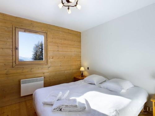 una camera con un letto bianco e una finestra di Appartement Montvalezan-La Rosière, 3 pièces, 4 personnes - FR-1-398-638 a Montvalezan