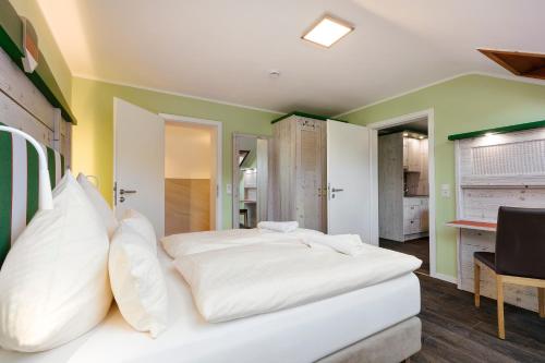 a bedroom with a large white bed with white pillows at Insulaner Ferienwohnungen in Helgoland