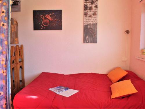 - un lit rouge dans une chambre avec une couette rouge dans l'établissement Studio cosy à Risoul 1850 - 4 couchages, pied des pistes, parking, balcon - FR-1-330-543, à Risoul