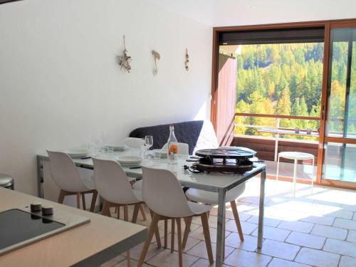 une salle à manger avec une table et des chaises et une grande fenêtre dans l'établissement Studio cosy à Vars Les Claux, 4 couchages, balcon sud, au pied des pistes et proche commerces - FR-1-330B-191, à Vars