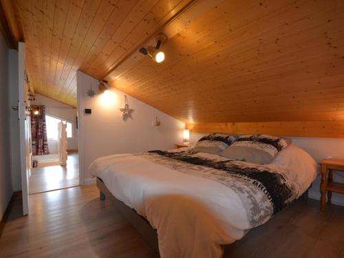 a large bed in a room with a wooden ceiling at Appartement Cohennoz, 4 pièces, 5 personnes - FR-1-505-152 in Cohennoz