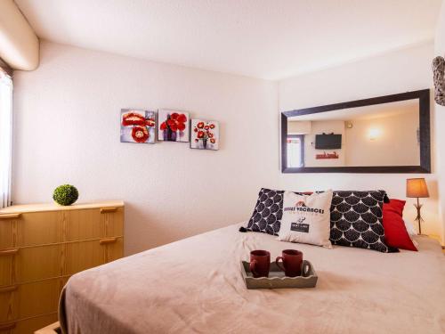 une chambre avec un lit, une commode et un miroir dans l'établissement Appartement cosy, 4 pers., proche pistes, Pla d’Adet – Saint Lary 1700 - FR-1-296-362, à Saint-Lary-Soulan