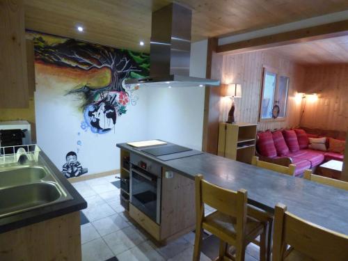 une cuisine et un salon avec une peinture sur les arbres sur le mur. dans l'établissement Charmant Studio de 50m² pour 2, pieds des pistes au Chinaillon - FR-1-458-153, au Grand-Bornand