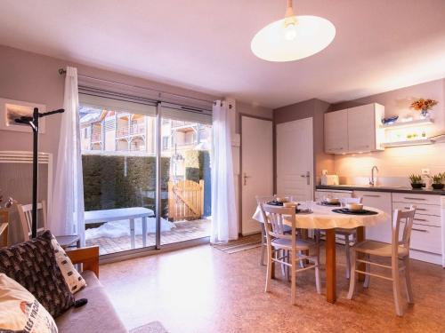 une cuisine et une salle à manger avec une table et une table et des chaises dans l'établissement Confort et Accès Facile : Proche Télécabine, 2 Chambres - FR-1-296-364, à Saint-Lary-Soulan