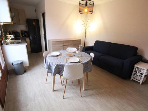 un salon avec une table et un canapé dans l'établissement T2 à Luchon avec Parking, Wifi et Animaux admis - FR-1-313-207, à Luchon