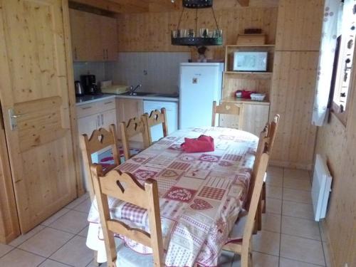 une petite cuisine avec une table et un réfrigérateur dans l'établissement Chalet 3 étoiles avec grande terrasse, garage et accès aux randonnées - FR-1-573-52, à Le Biot