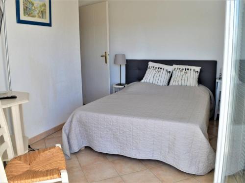 ein Schlafzimmer mit einem großen Bett in einem weißen Raum in der Unterkunft Appartement Climatisé 2 Pièces avec Balcon et Garage Privatif à Cavalaire-sur-Mer - FR-1-226B-101 in Cavalaire-sur-Mer