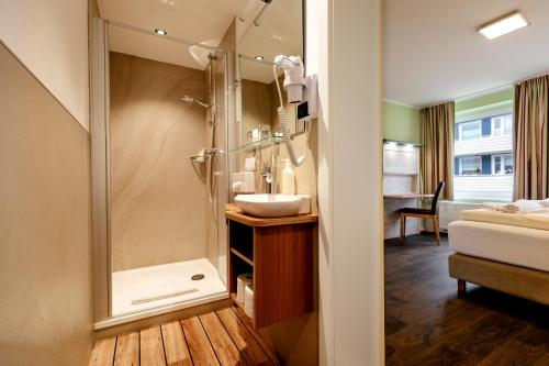 ein Bad mit einer Dusche und einem Waschbecken in der Unterkunft Insulaner Ferienwohnungen in Helgoland