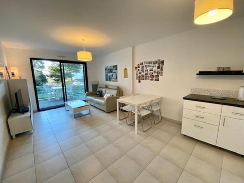 une cuisine et un salon avec une table et un canapé dans l'établissement Quiberon : Superbe T3 63m² avec Balcon, Parking, et WIFI – Proche Thalasso, Animaux Acceptés ! - FR-1-478-206, à Quiberon