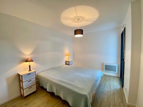 une chambre avec un grand lit blanc et deux lampes dans l'établissement Quiberon : Superbe T3 63m² avec Balcon, Parking, et WIFI – Proche Thalasso, Animaux Acceptés ! - FR-1-478-206, à Quiberon