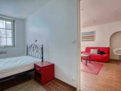 um quarto com uma cama e um sofá vermelho em Appartement Saint-Jean-de-Luz, 2 pièces, 5 personnes - FR-1-4-619 em Saint-Jean-de-Luz
