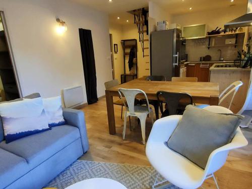 un salon avec un canapé, une table et des chaises dans l'établissement Beau duplex rénové centre Cauterets, 6-8 pers, proche télécabines/thermes, WiFi - FR-1-234-274, à Cauterets