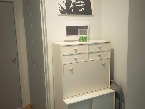 - une commode blanche avec une horloge en haut dans l'établissement Charmant T2 avec coin cabine, parking et casier à skis - Bolquère - FR-1-592-38, à Bolquère-Pyrénées 2000