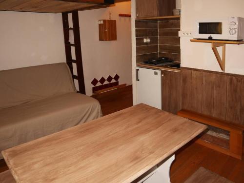 Cette petite chambre comprend une table, un lit et une cuisine. dans l'établissement Studette rénovée proche pistes et centre Les Orres - FR-1-322-465, aux Orres